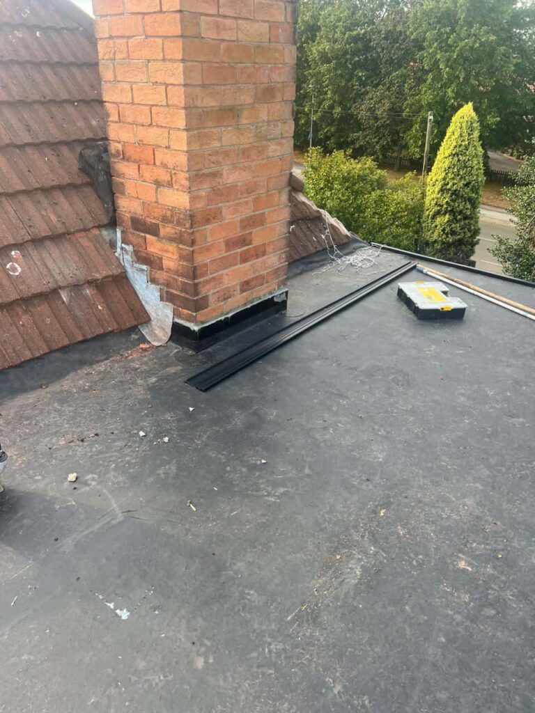 This is a photo of a flat roof which has just been repaired, there is also a chimney stack and some leadwork has also been dressed. Works carried out by LJ Roofing Bradford on Avon